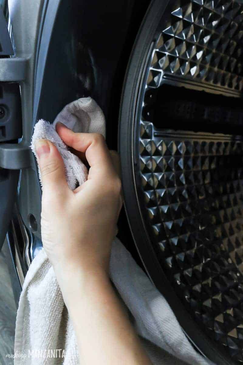 Wiping the rubber door of washing machine with a wet rag soaked in water and cleaning vinegar.