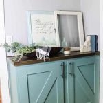 Hallway built in cabinet painted with blue green paint color and decorated with modern farmhouse style with text overlay that says DIY storage cabinet