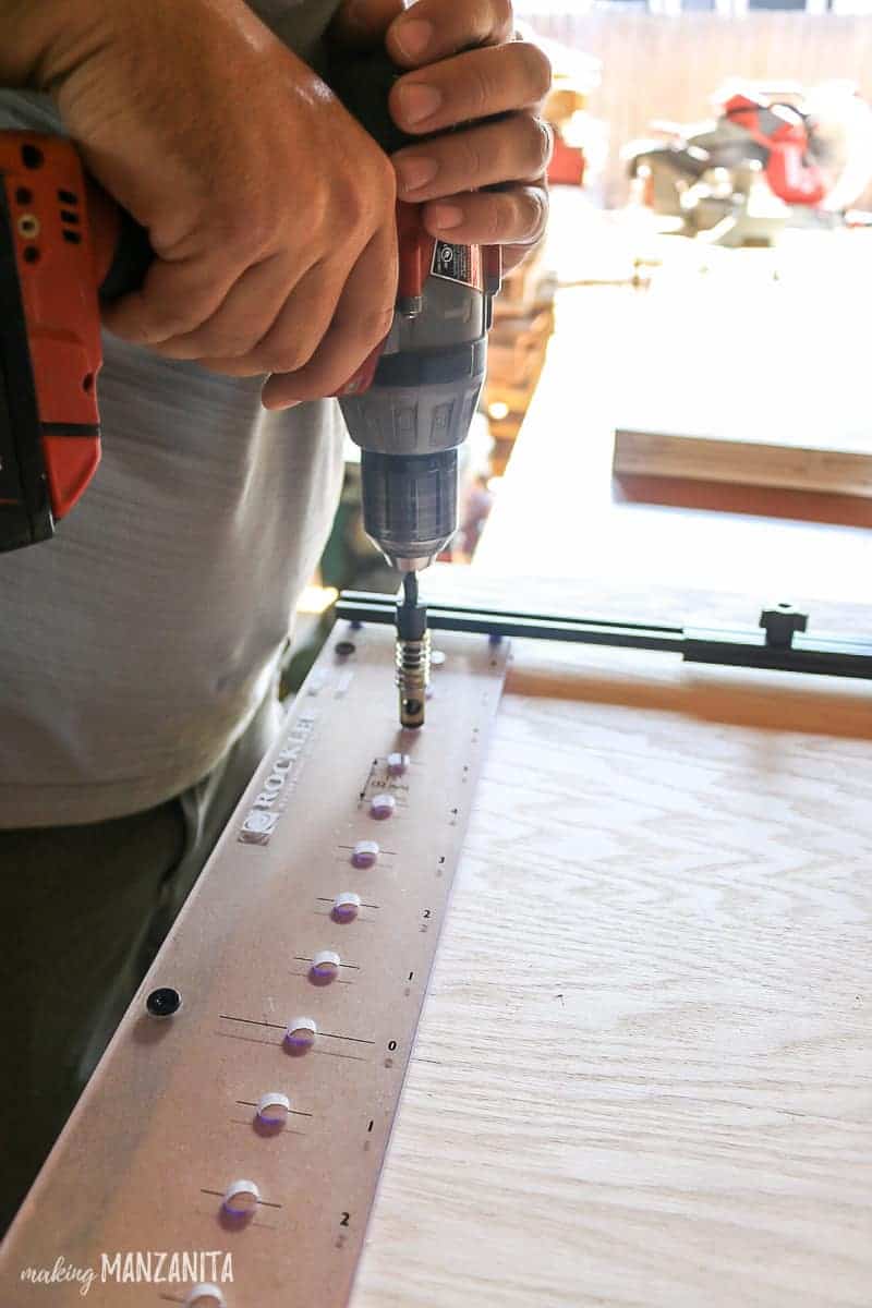 Using a drill and Rockler's pro shelf drilling jig to create the holes for the shelves of our hallway cabinet.