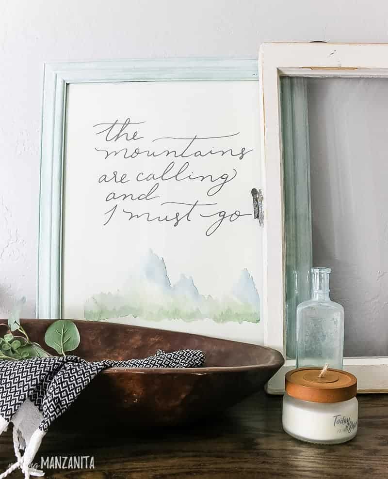 A closer look at the countertop decor on our hallway cabinet - a framed print, vintage window, and wooden bowl