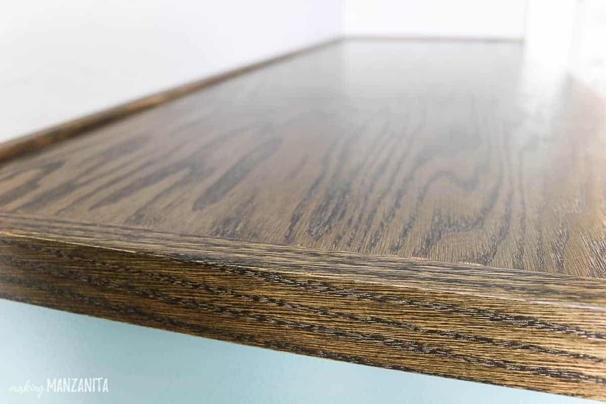 A close up look at the smooth, perfect finish of the stained wood hallway cabinet countertop.