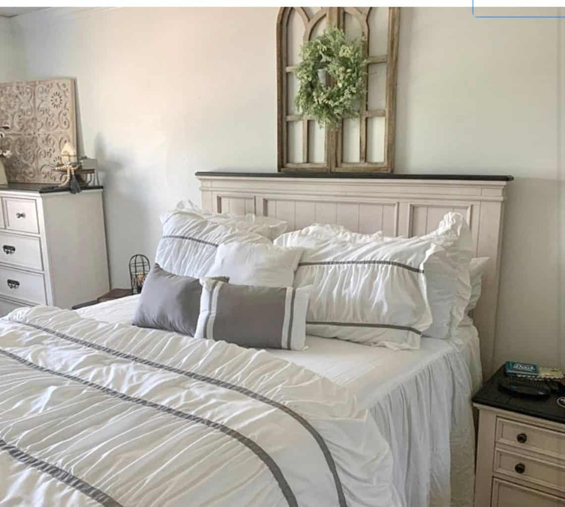 I love a wreath over the bed as decorations! This one look great centered on the wall above the headboard layered on a wooden cathedral window. 