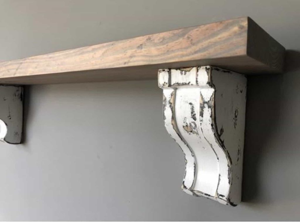 Adding a shelf above your bed is a great way to add extra decorations that can be swapped out regularly. How gorgeous is this large shelf with corbels? 