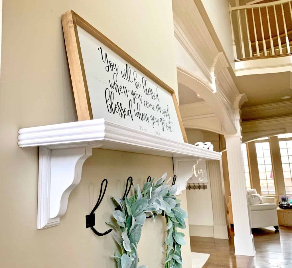 A shelf is a great solution in your bedroom for over the bed door. I love this white farmhouse shelf with chunk carved corbels 