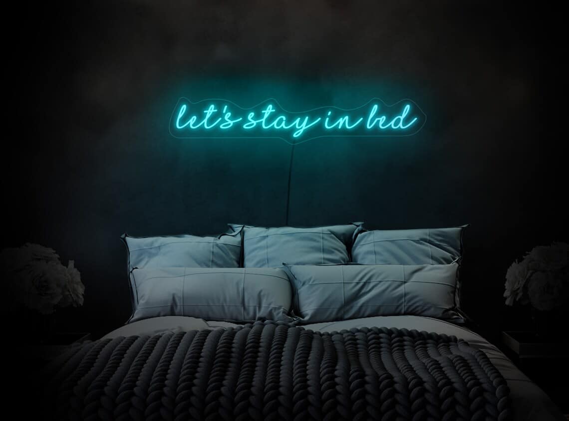 Not only is it a great way to add a simple nightlight to your bedroom, but you can customize a neon sign to add your favorite quote, like this one that says let's stay in bed.