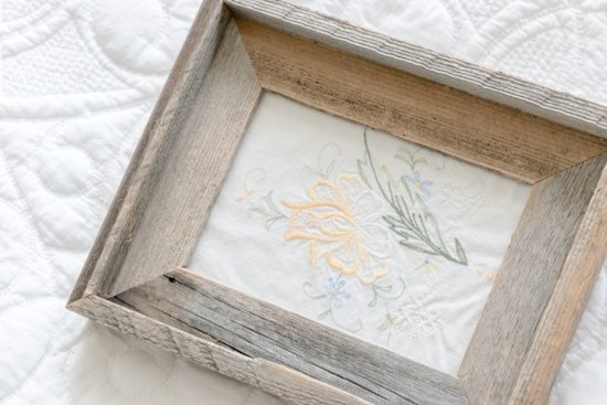 Barnwood frame holding vintage inspired embroidery art 