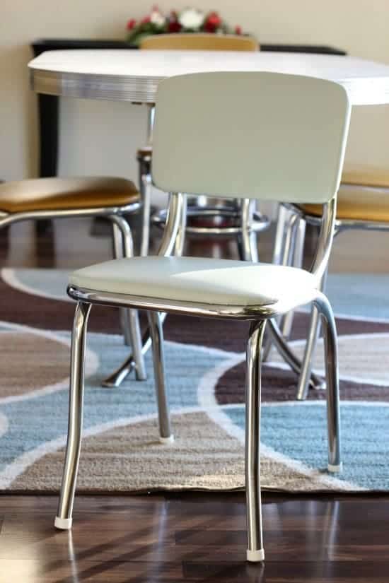 Vintage diner chair with brand new upholstery in light tan color sitting in kitchen in front of vintage looking table