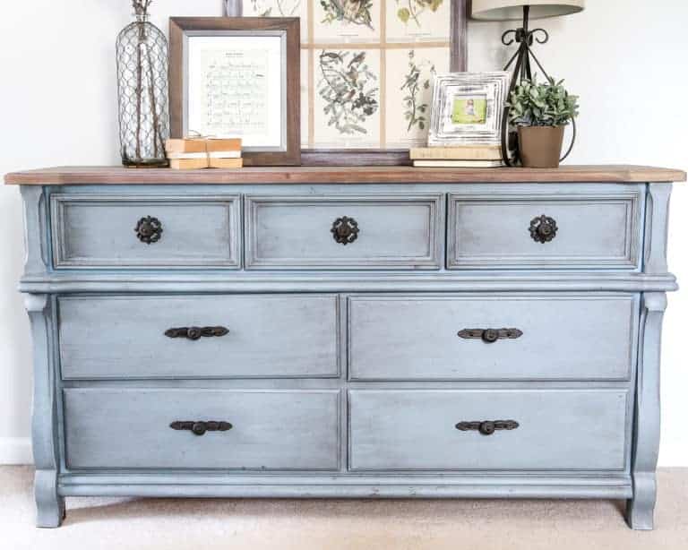 Gray blue painted vintage dresser with black hardware and farmhouse decorations on top