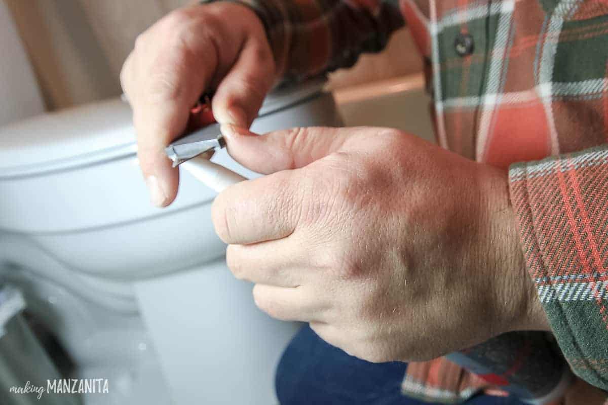 Using a utility knife to open a new tube of caulk