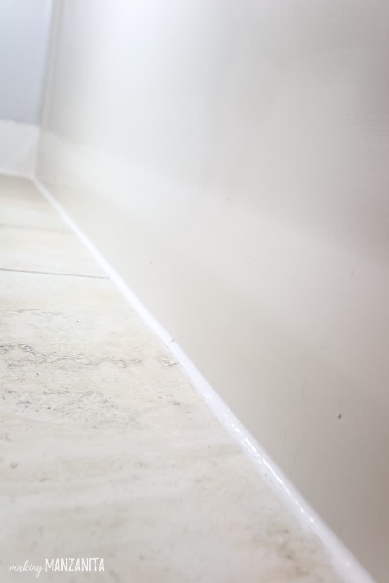 A fresh line of caulk on the bathroom floor where the bathtub meets the tile floor