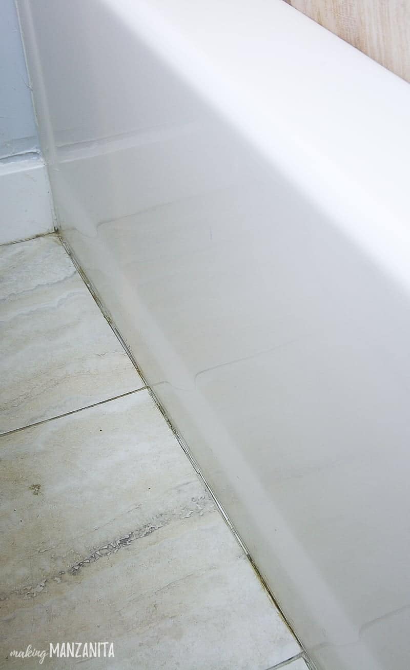 Caulk line at the base of a bath tub where the flooring meets the tub that dirty and cracked and needs replacing