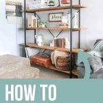 Fixer upper inspired shelves decorated with vintage books, baskets, scale, corbels and a suitcase with text overlay that says how to decorate shelves