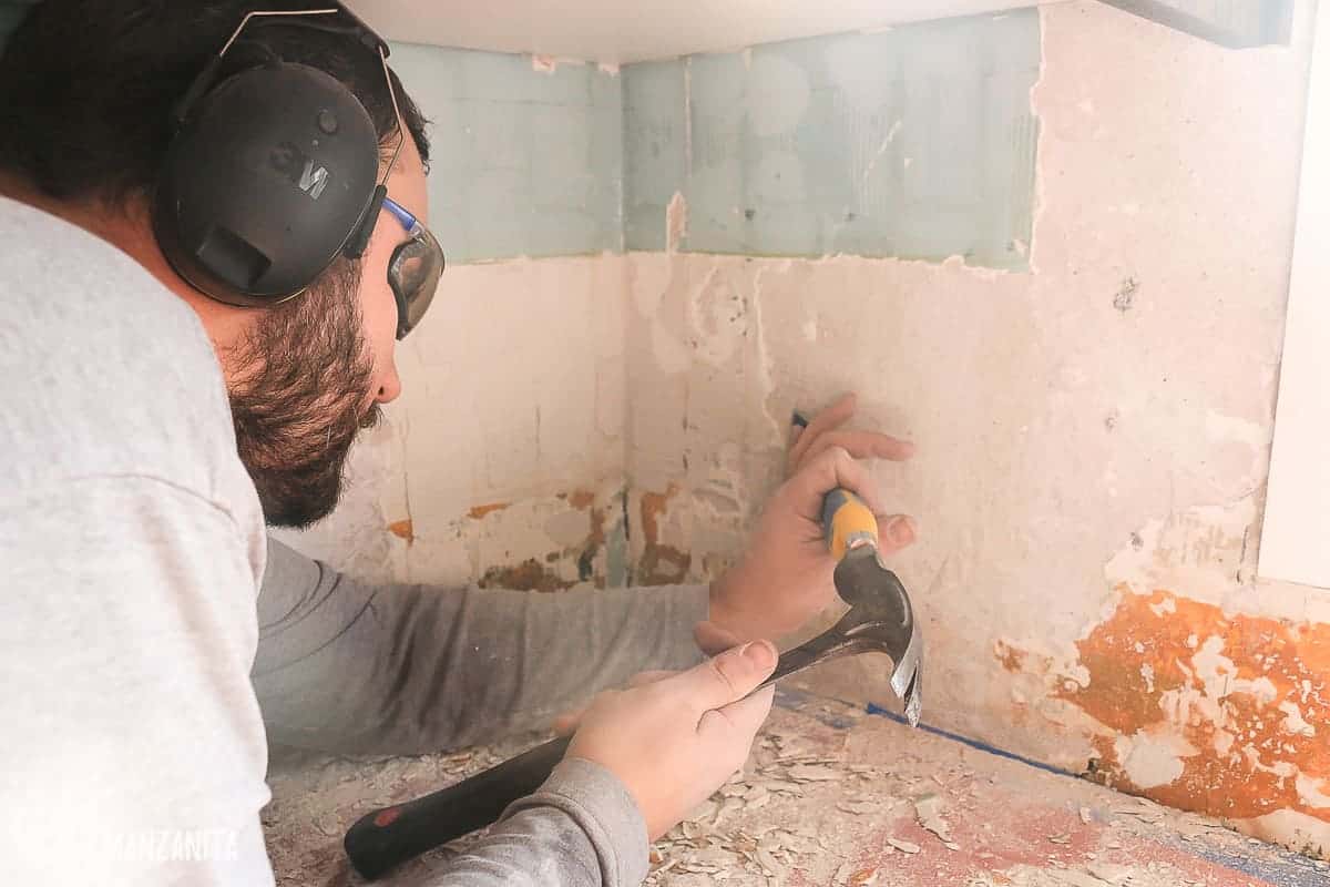 After removing all the backsplash tile, it's time to scrape down the walls to remove all the remaining adhesive