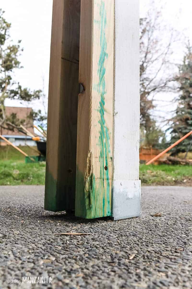 Copper green wood preservative sprayed on the bottom of 2x3s used for DIY porch posts to add curb appeal