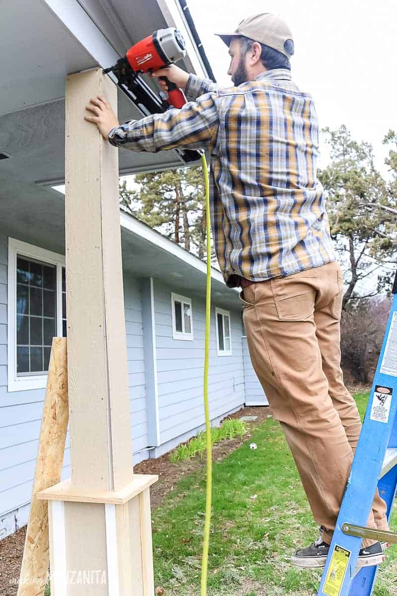 Man standing on ladder adding column wrap to porch post make with exterior siding and trim for a craftsman style