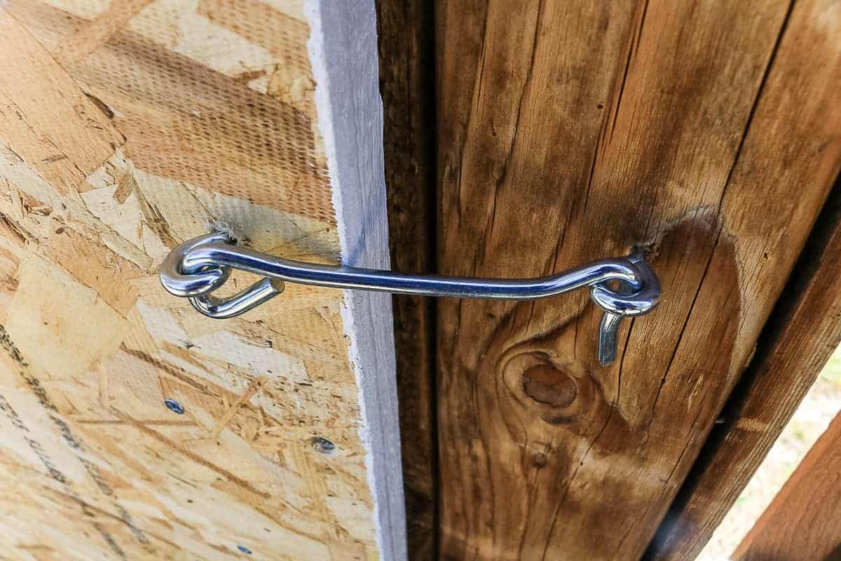 Eye hooks attach to the fence and outdoor chalkboard box doors to keep the doors from swinging when opened.