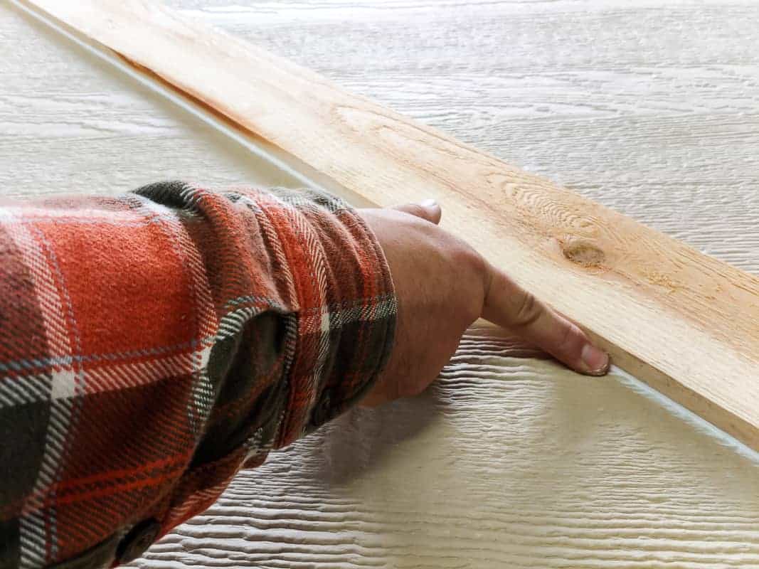 Caulking the joints of the door frame for our outdoor chalkboard storage box.