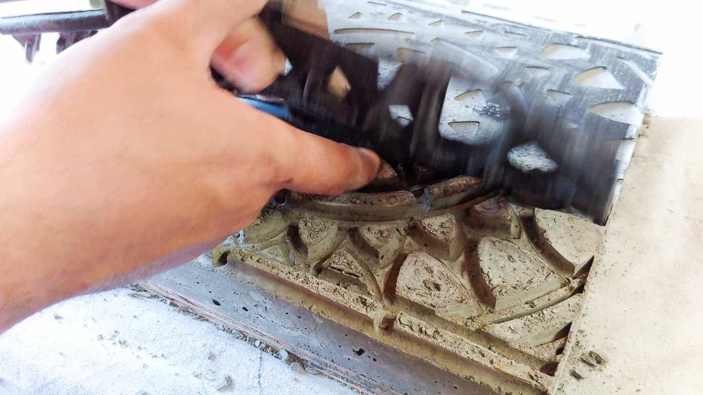 Removing the rubber doormat mold from the hardened concrete stepping stone