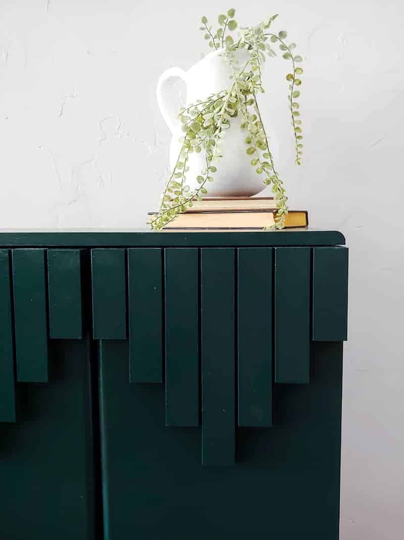 Dark green laminate cabinet makeover focusing the right side trim pieces design with farmhouse decor on top of it.