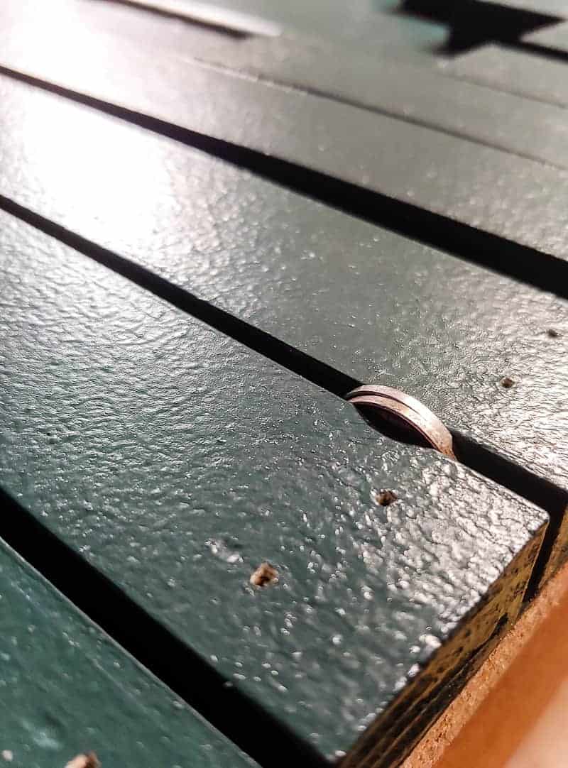 Trim pieces with two nickle used as spacer on a laminate cabinet makeover.