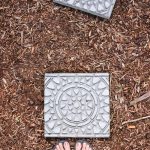 Photo of garden stepping stones with feet on the ground.