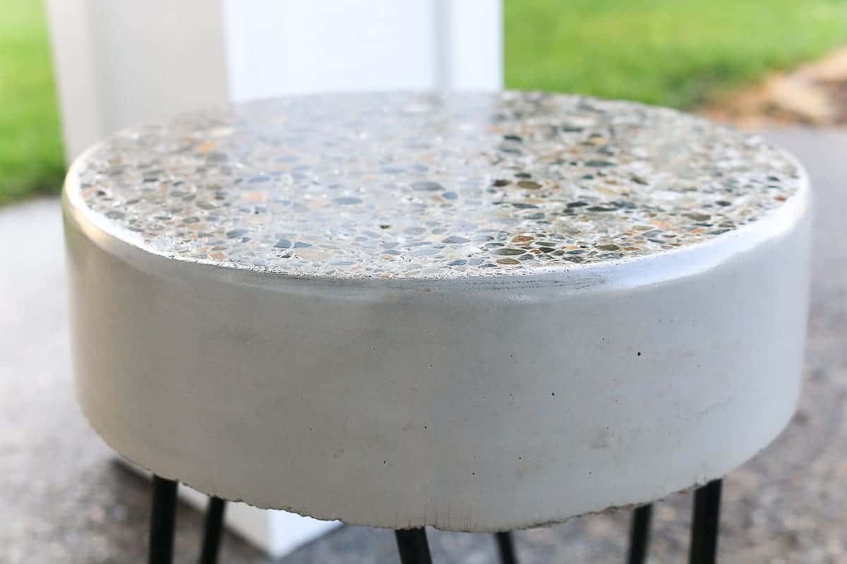 This DIY concrete patio side table is finished with a stylish mosaic top