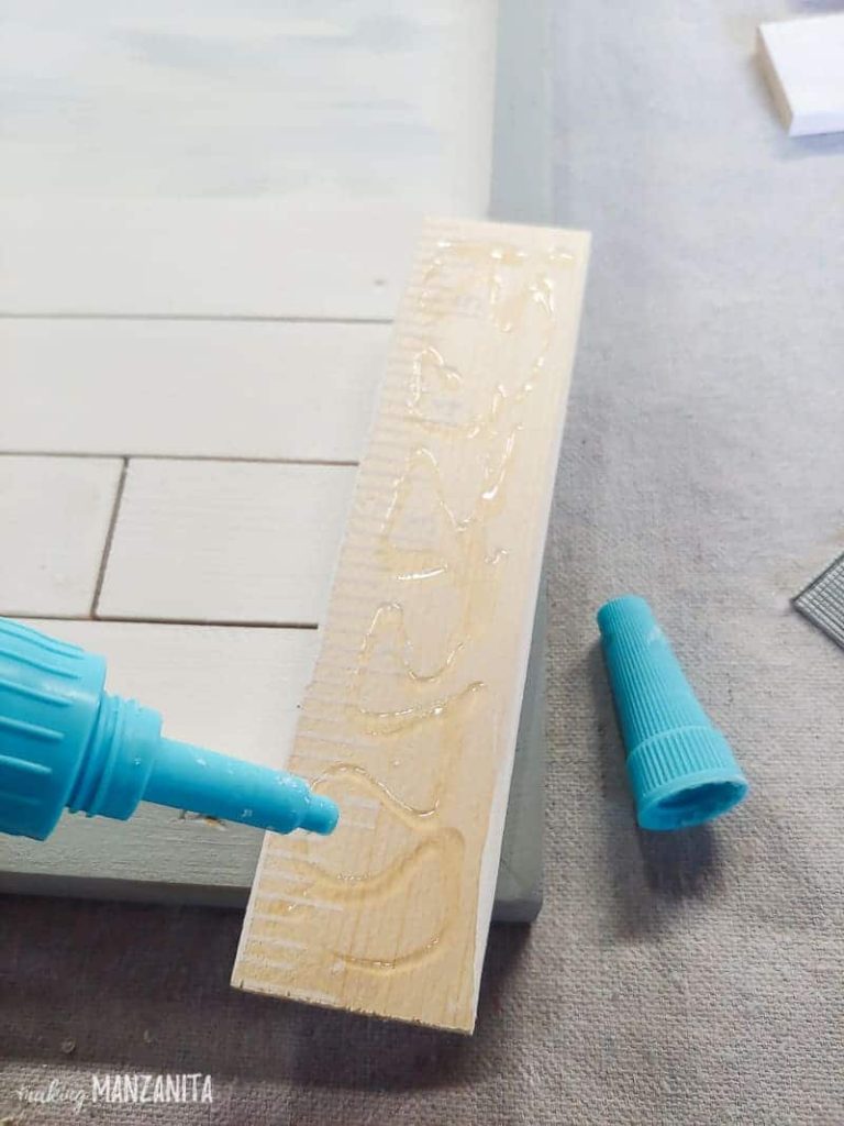 Applying glue at the back of the mini shiplap.