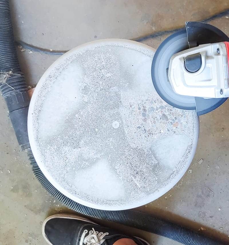 Using a sander to level out the top of our DIY concrete patio table