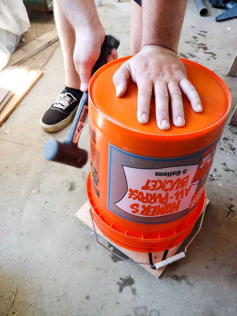 Attempting to release the concrete side table from the plastic casting bucket