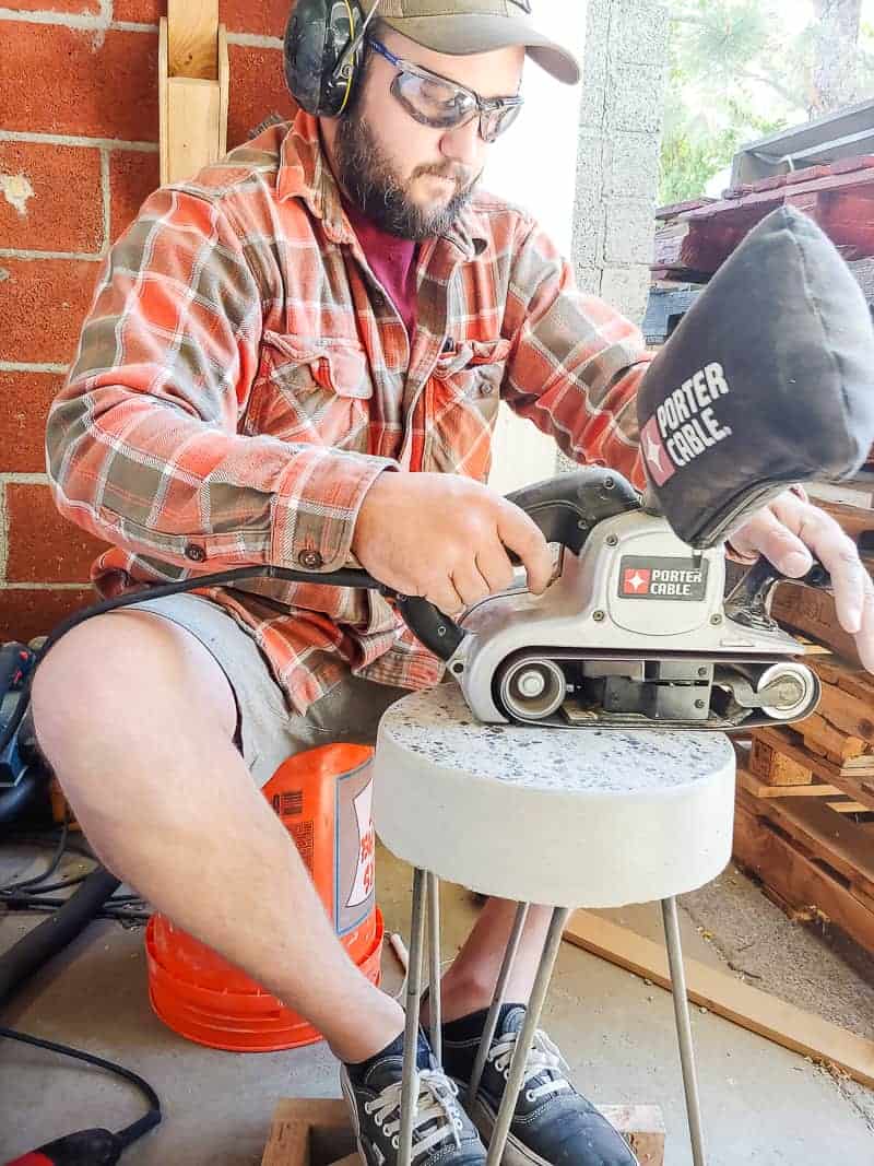 Using a grinder to finish and level out the top of our DIY concrete patio table