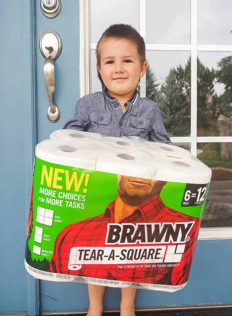 Preschooler boy holding a pack of paper towels
