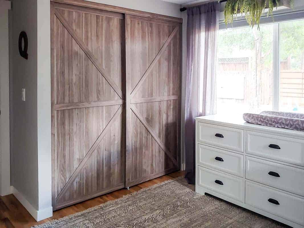 the closet in our baby girl nursery is finished with gorgeous rustic barn doors and complete the farmhouse style theme.
