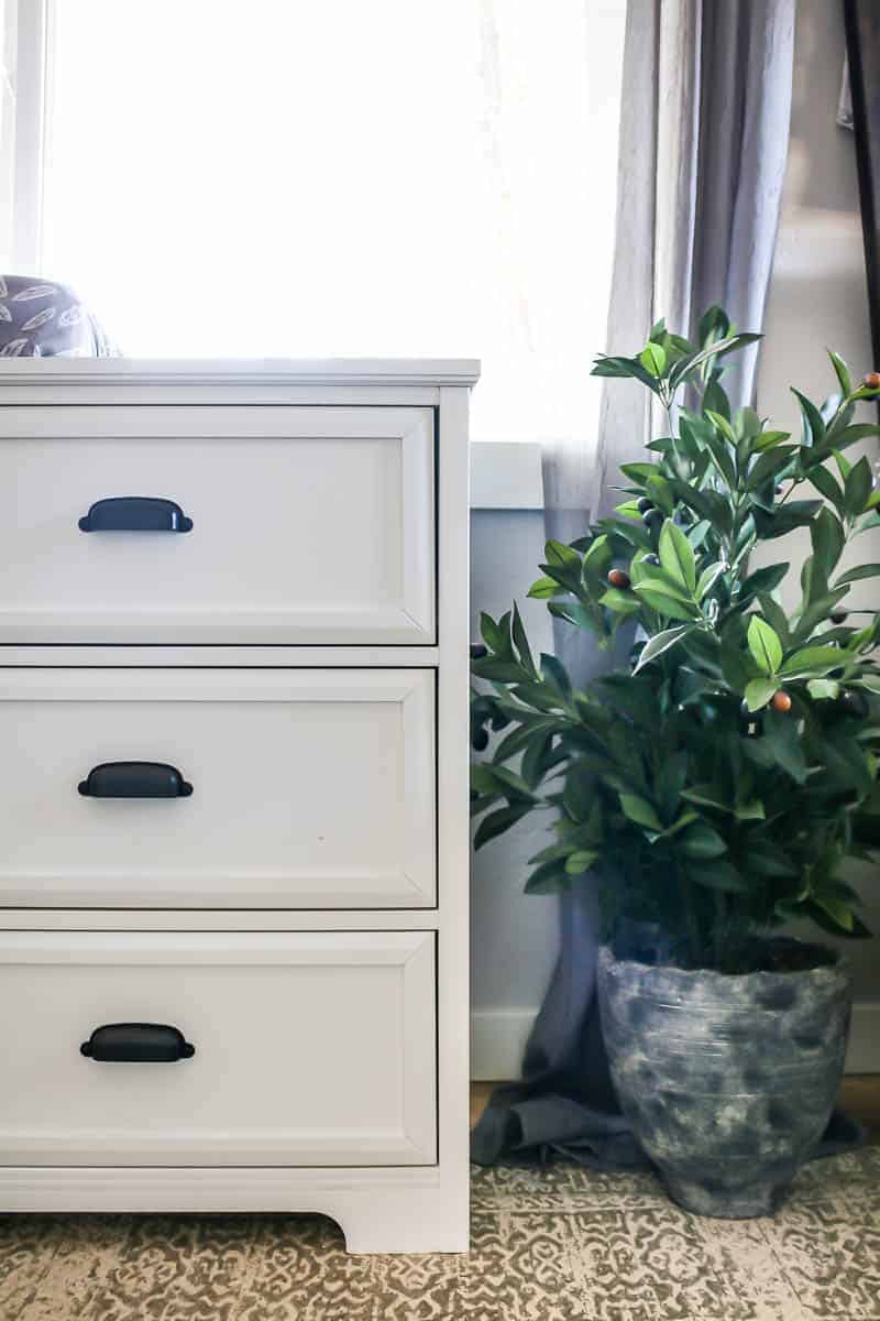 this white 6-drawer changing table is perfect for our baby girl's nursery, with plenty of storage for baby essentials! We added greenery with a gorgeous potted plent.