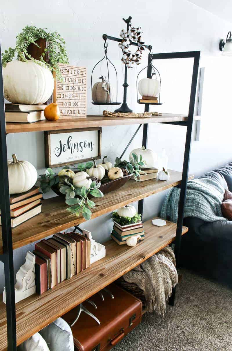 A look at our Fall themed living room bookshelves - adorned with fun fall decor like stacked vintage books, pumpkins and gourds, greenery and more. This living room shelf decor is perfect for the fall season.