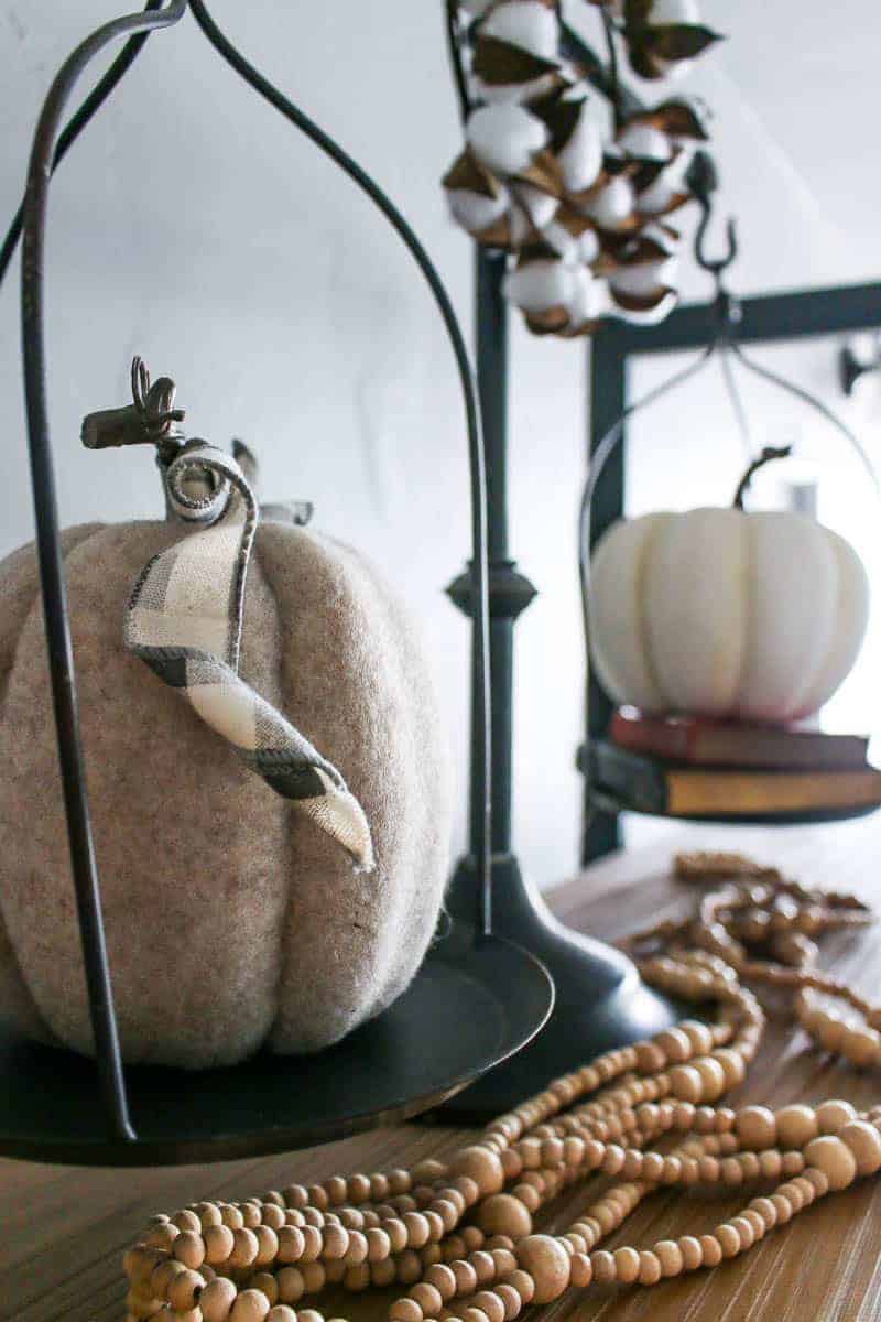 A close up look at the faux fabric pumpkins that sit on the vintage scales as part of my fall themed living room shelf decor.