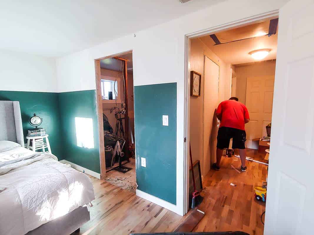 A look from inside our master bathroom: we have a new bathroom door on the left side of the bedroom door, and Logan is closing up the old bathroom entry in the hallway.