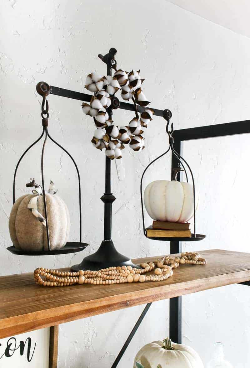 I added these vintage scales to my living room shelf decor and added two faux pumpkins and some faux cotton blooms to give them a fall theme.