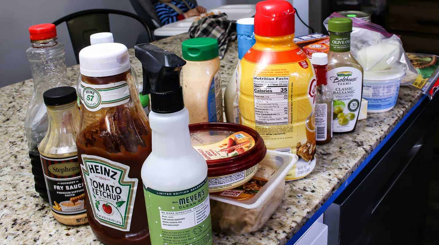 Food and sauces on the countertop taken out of the refrigerator during a fridge clean out