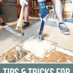 Removing the tile floor using hammer photo with text overlay that says Tips & Tricks For Removing Tile Floors