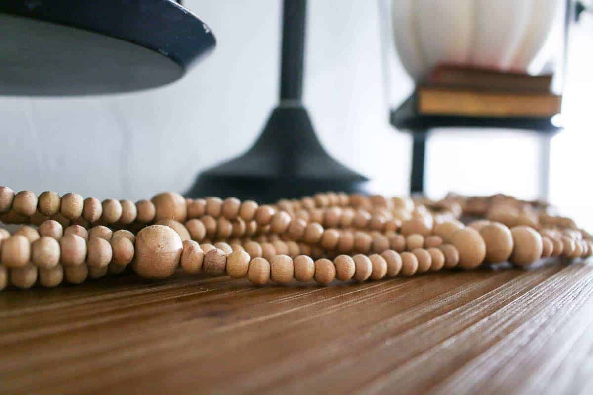 This wooden bead garland is perfect living room shelf decor - and it's just a repurposed plant hanger that I haven't hung up yet!