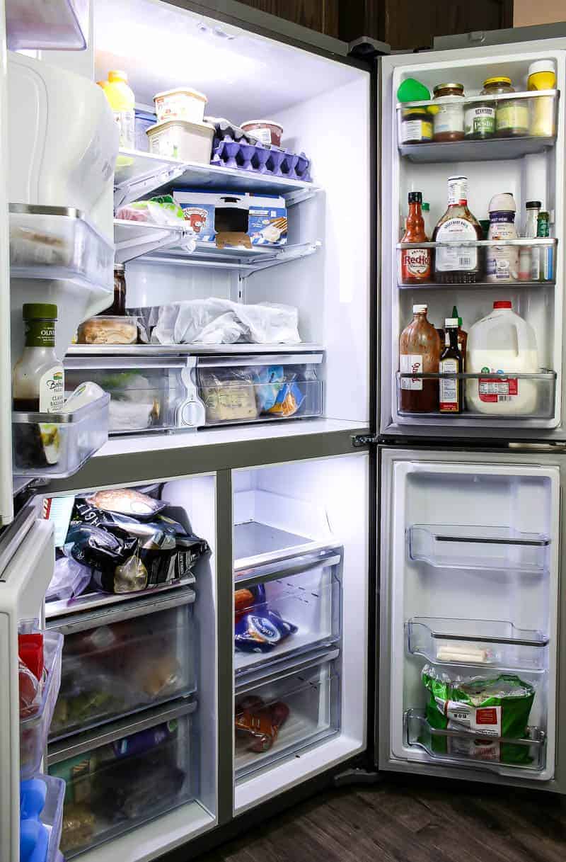Opened refrigerator doors showing the entire shelves and the food inside