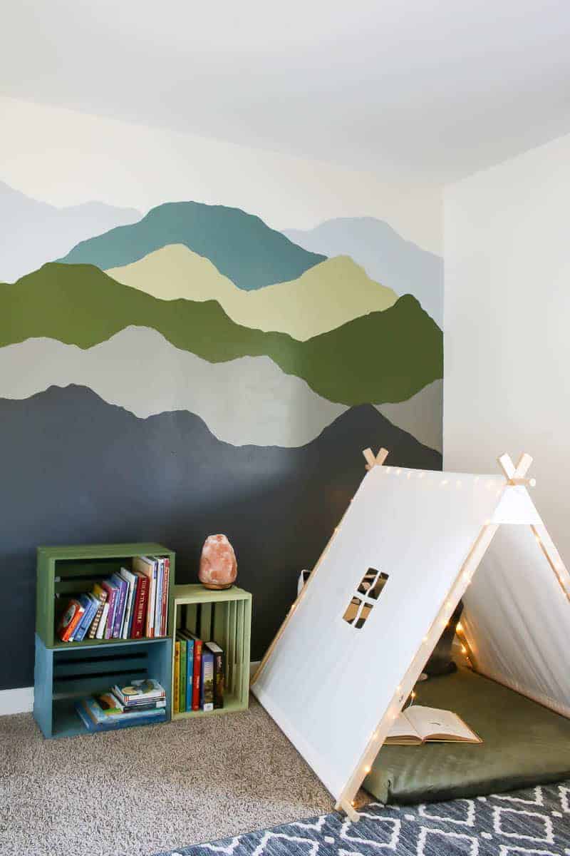 Mountain mural, colorful pallet bookshelves and toddler reading nook with teepee tent and dog bed for floor mat