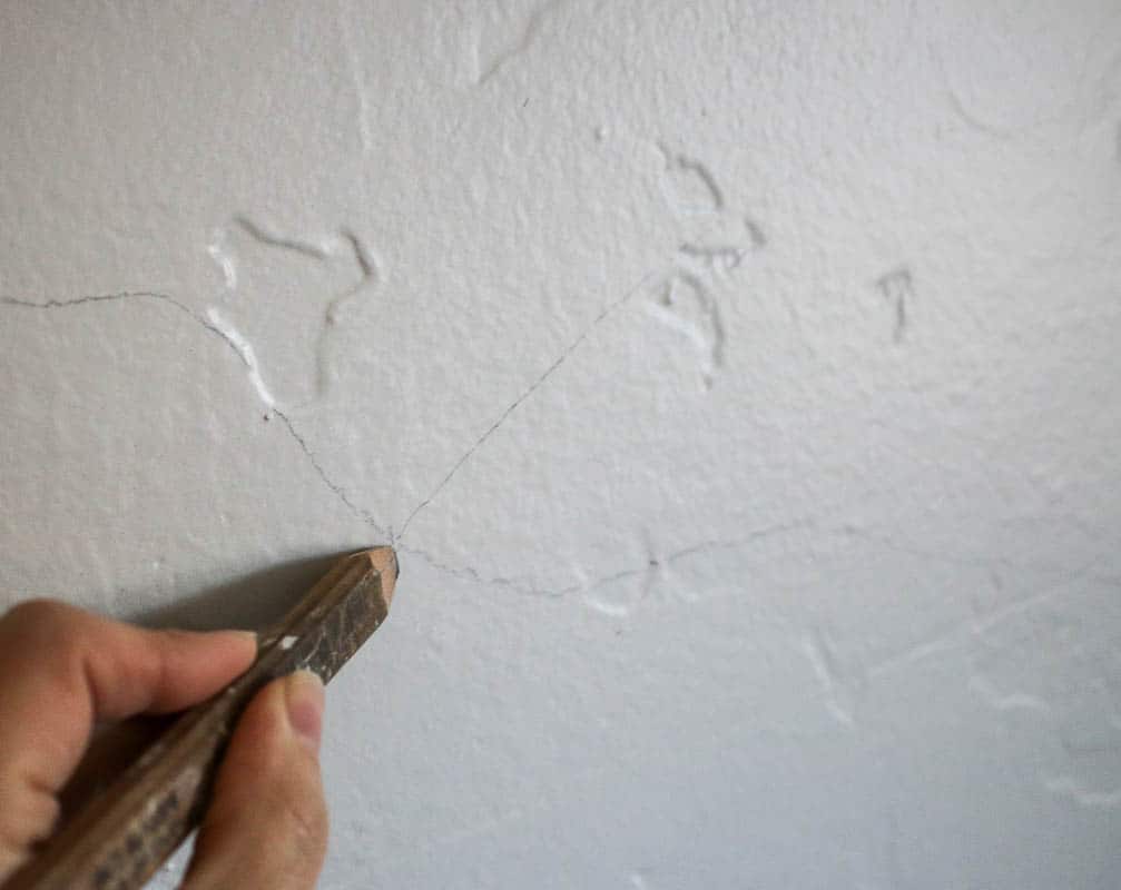 Drawing the art design on the mountain mural wall using a pencil