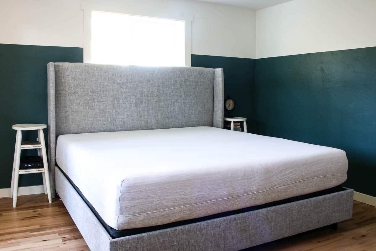 Our king bed, up against a two toned wall painted white and jade green.