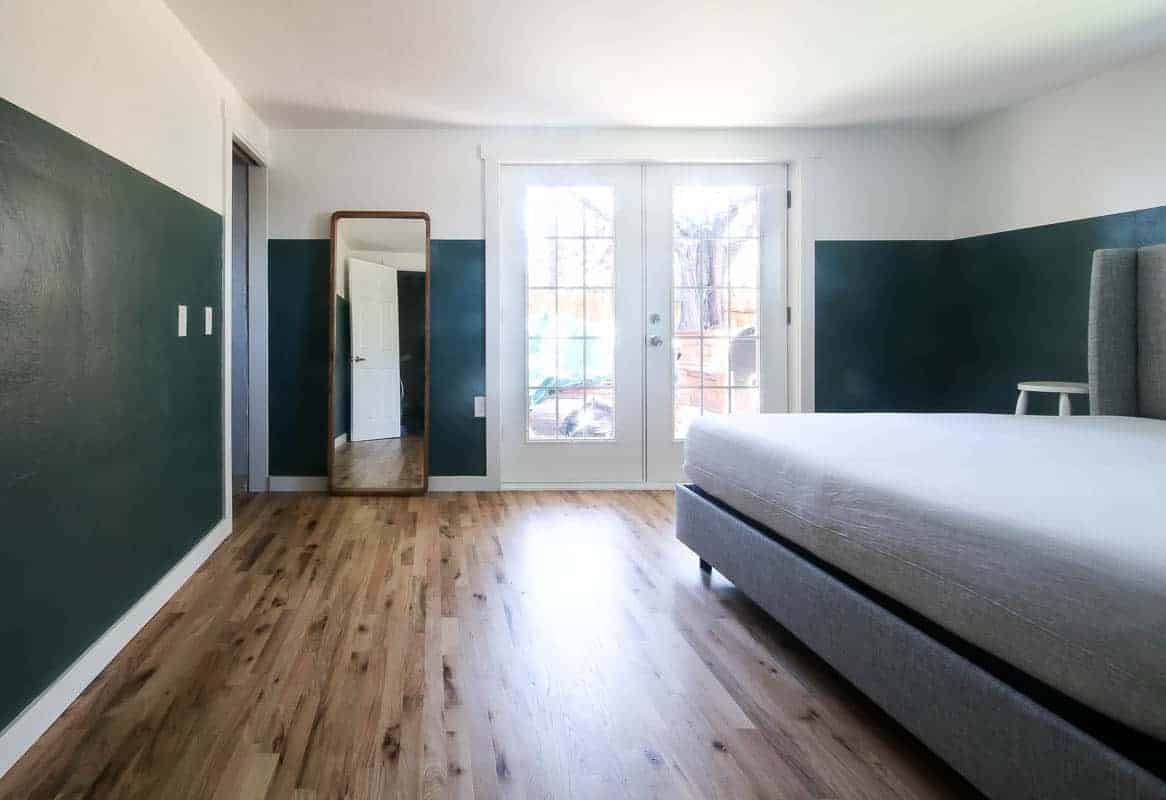 Perfectly painted straight lines all around our bedroom, creating two toned walls - the top portion of the walls are white, the lower portion is a deep jade green.