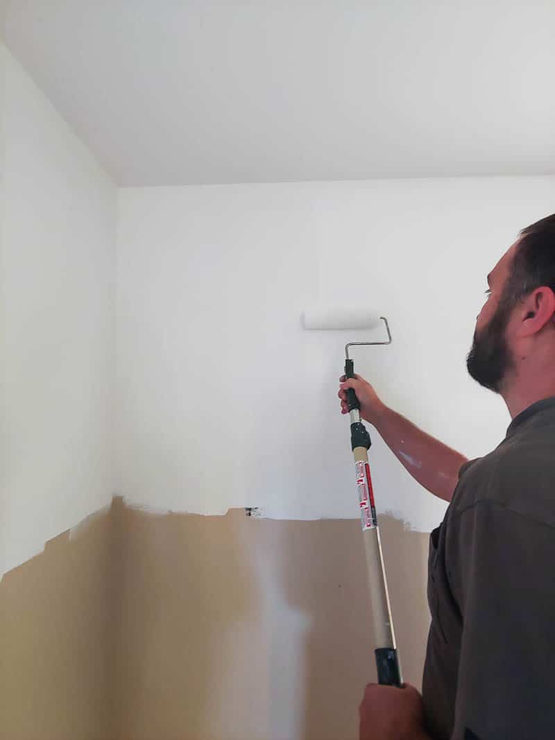 Logan painting the first coat of paint on the top half of our two toned walls in the master bedroom.