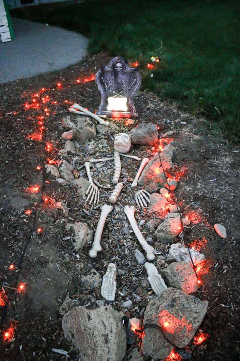 Fake skeletons scattered in a fake graveyard with red lights.