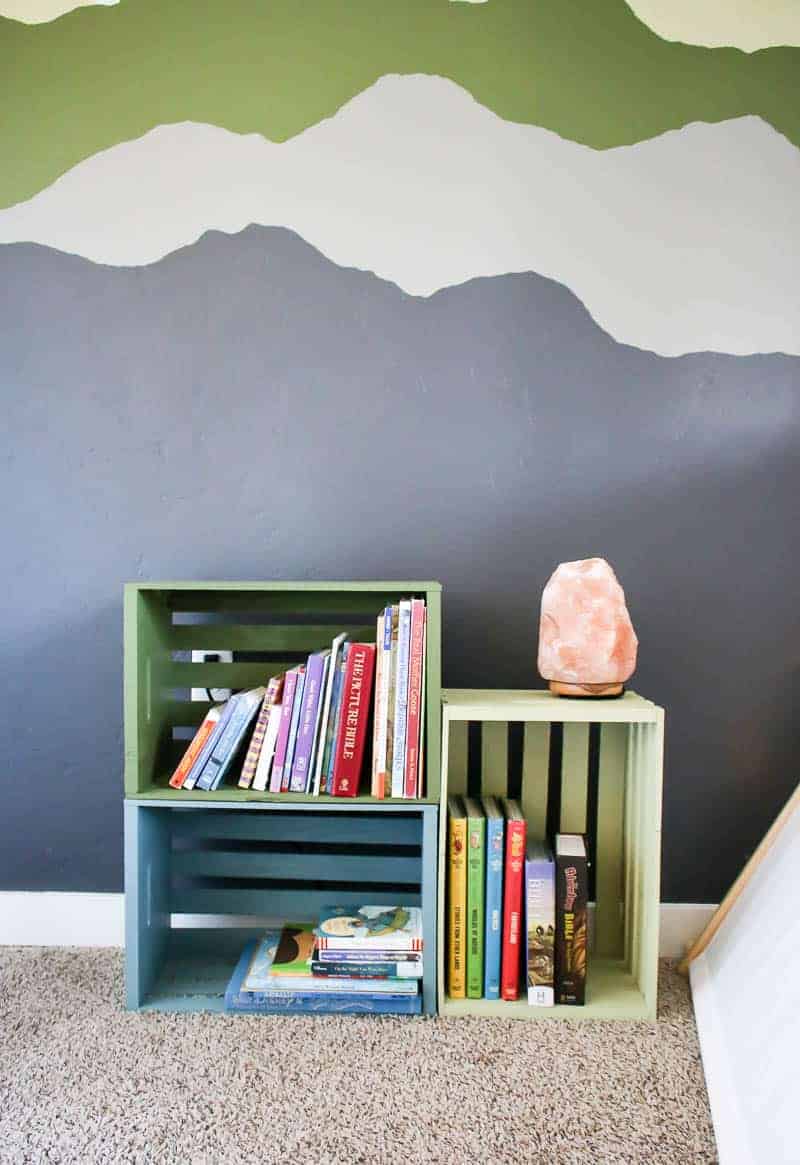 Painted wall behind the colorful painted wood crate bookshelves for toddler play room