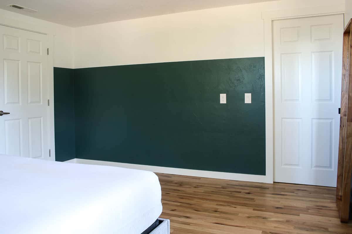 A two toned painted wall, with perfectly straight lines made using Frog tape. The walls are white and jade green in our master bedroom