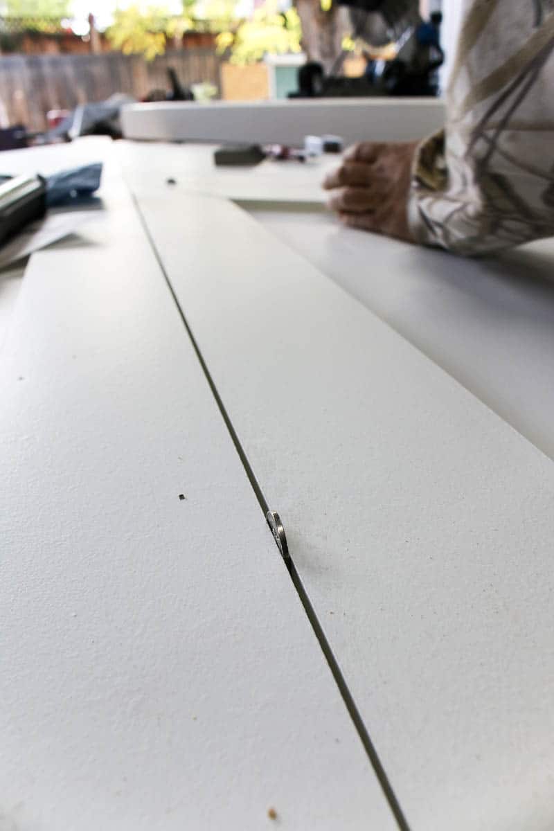 When creating the X design on the back of a barn door, using a nickel is a creative way even space out the wooden slats.